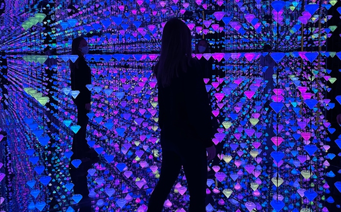 Visitor exploring Moco Museum Barcelona exhibit with colorful reflections and mirrors.