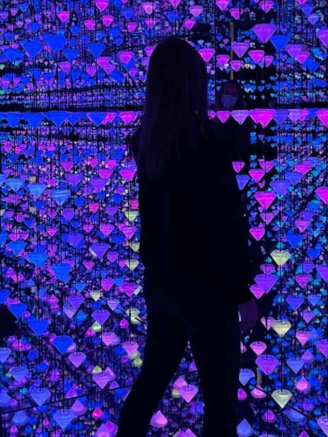 Visitor exploring Moco Museum Barcelona exhibit with colorful reflections and mirrors.