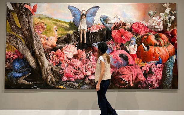 Visitor observing surreal artwork at Moco Museum Barcelona exhibit.