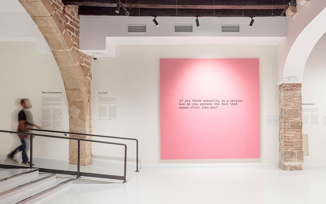 Moco Museum Barcelona interior with pink artwork featuring text.