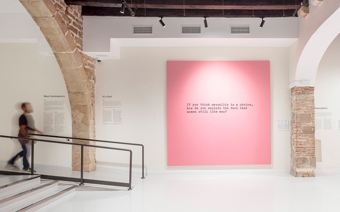 Moco Museum Barcelona interior with pink artwork featuring text.