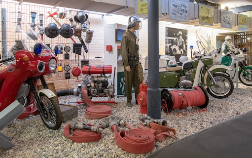 Motorcycles and firefighting equipment display at DDR Museum exhibition.