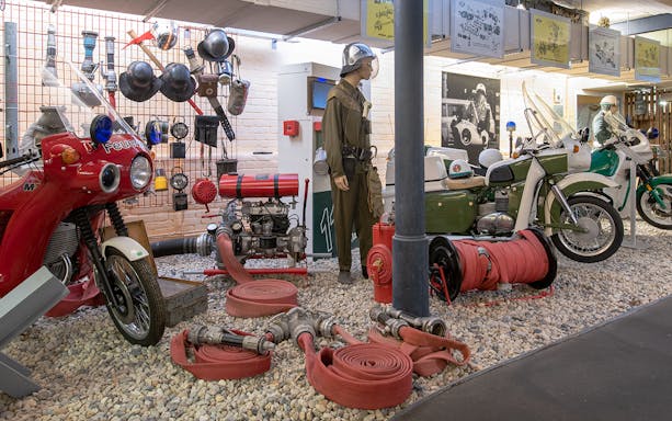 Motorcycles and firefighting equipment display at DDR Museum exhibition.