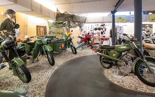 Motorcycles and military gear display at DDR Museum exhibition.