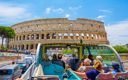Hop on hop off bus with tourists near the Colosseum, Rome.