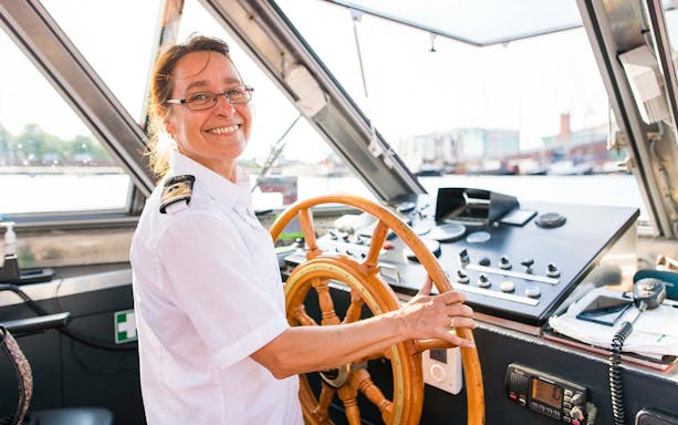 Boat captain steering during Half Day Hop On Hop Off Tour.