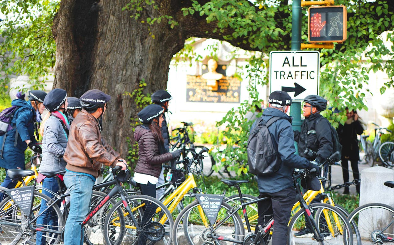 Cyclists gather near a sign in Central Park during a bike tour.