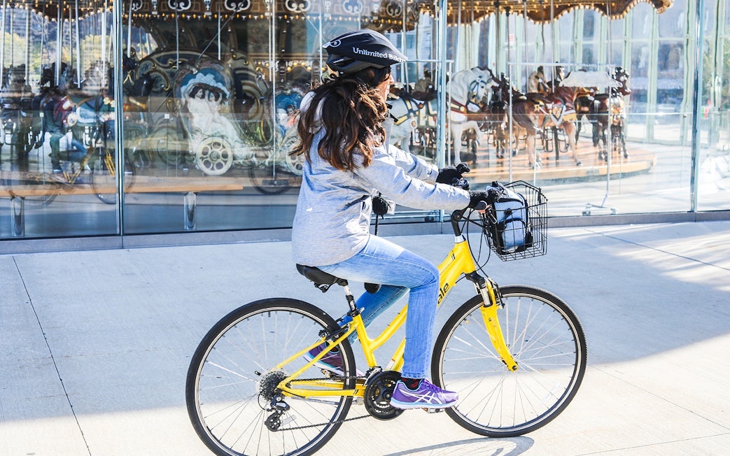 Person riding a yellow bike near Jane's Carousel in Brooklyn.