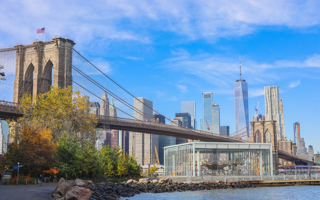 Brooklyn Bridge with Manhattan skyline and Jane's Carousel in the foreground.