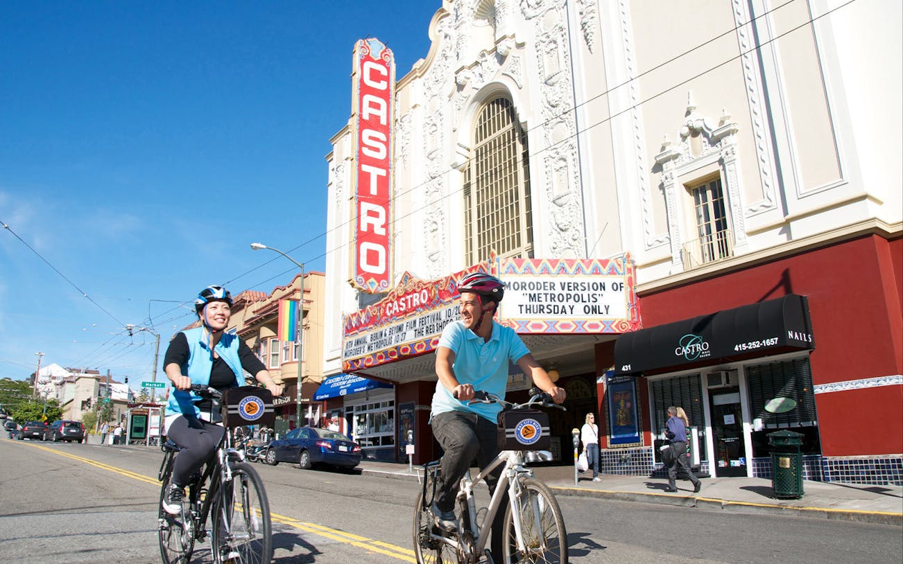 Cyclists on electric bikes in front of Castro Theatre, San Francisco.