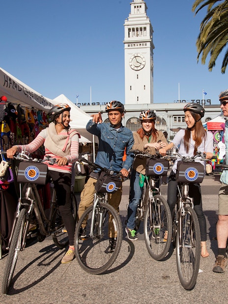 Group on electric bikes near San Francisco Ferry Building during guided tour.