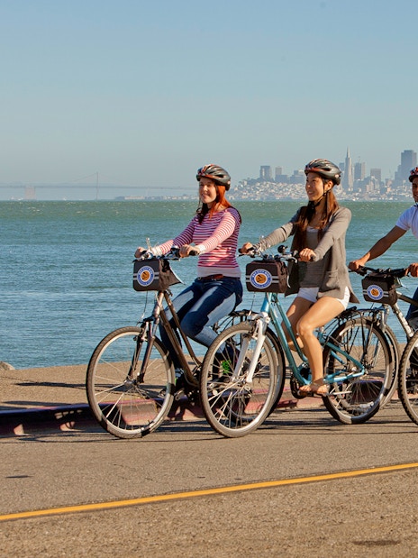 Cyclists on a guided tour from Golden Gate Bridge to Sausalito with San Francisco skyline.