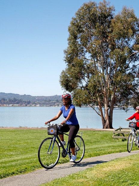 Cyclists on a path near water during Golden Gate Bridge to Sausalito bike tour.