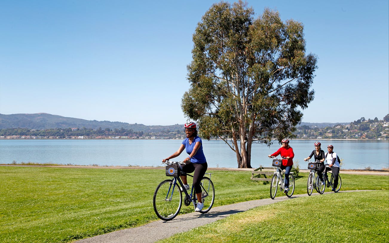 Cyclists on a path near water during Golden Gate Bridge to Sausalito bike tour.