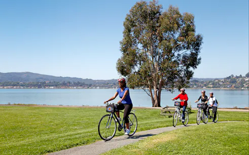 Cyclists on a path near water during Golden Gate Bridge to Sausalito bike tour.