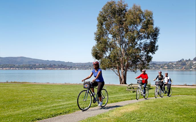 Cyclists on a path near water during Golden Gate Bridge to Sausalito bike tour.