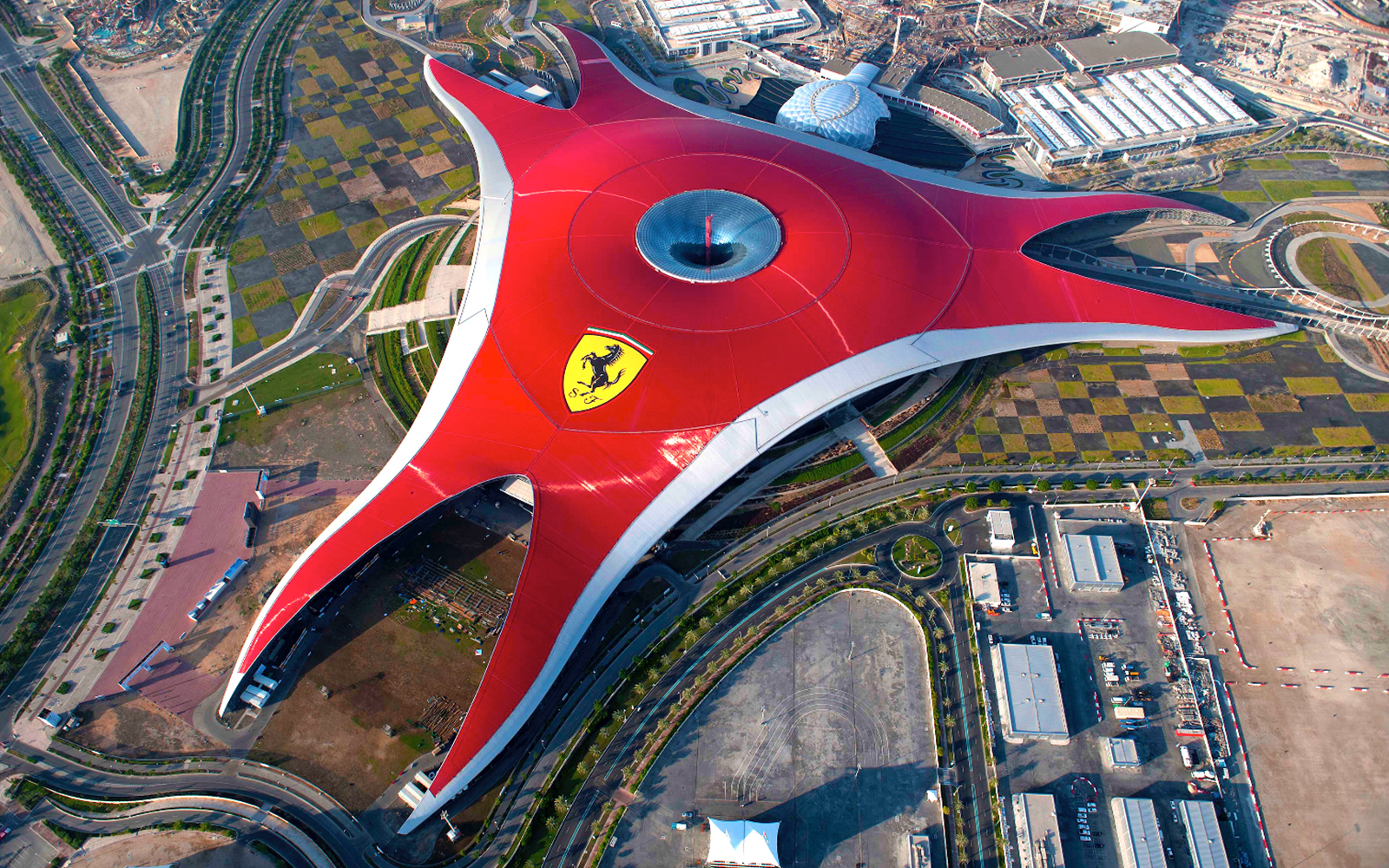 Aerial view of Ferrari World Abu Dhabi's iconic red roof structure.