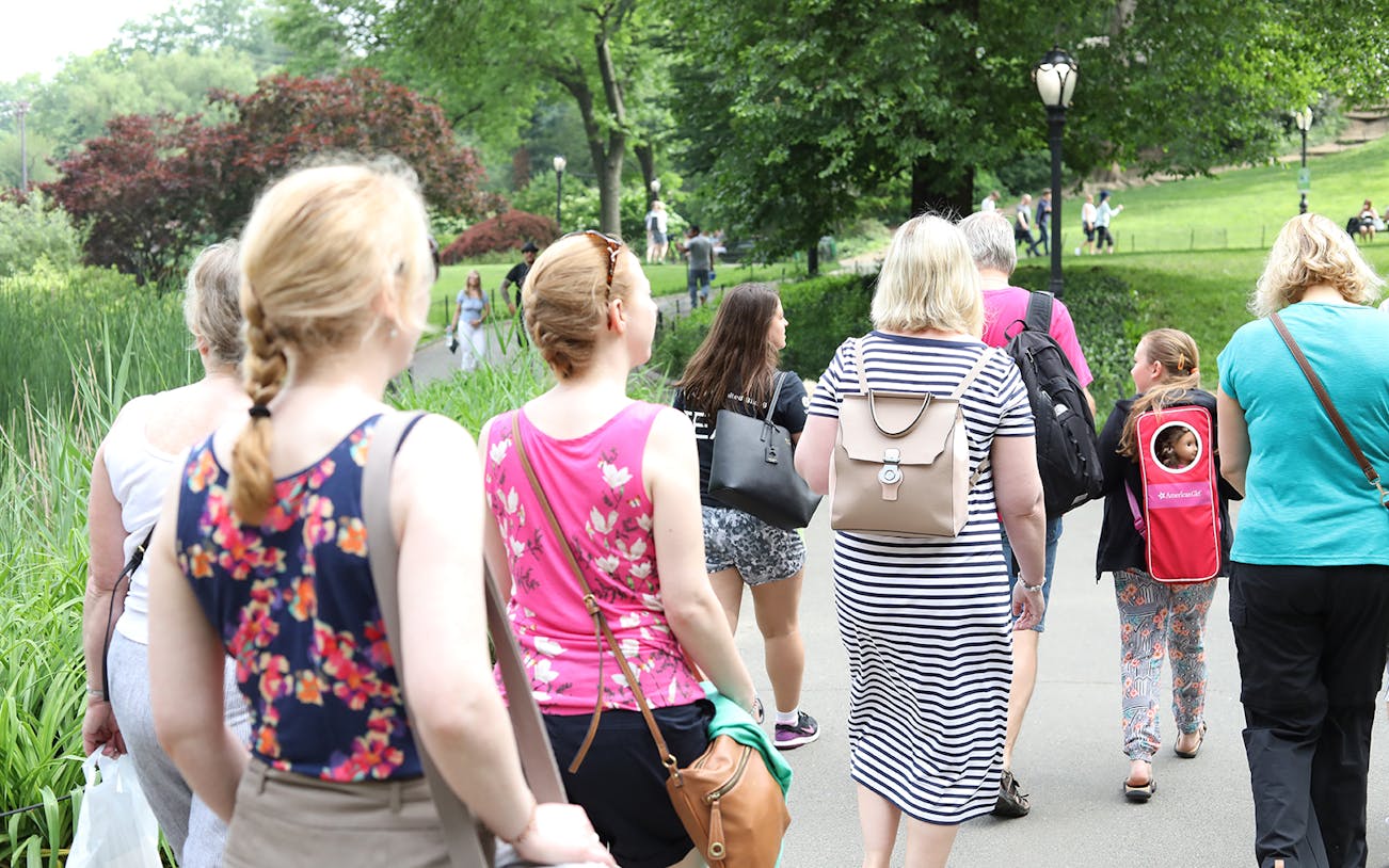 Group walking on a path in Central Park, surrounded by greenery.