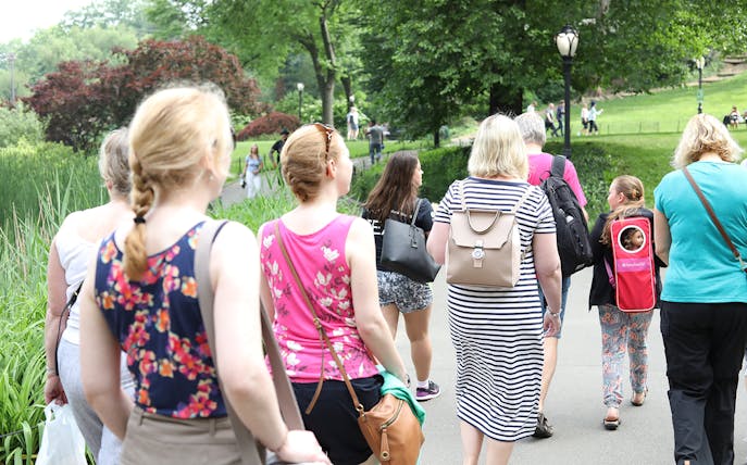 Group walking on a path in Central Park, surrounded by greenery.