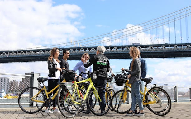 Group of cyclists with guide on Brooklyn Bridge bike tour.