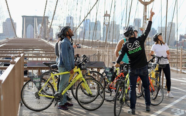 Cyclists with a guide on Brooklyn Bridge during a bike tour in New York City.