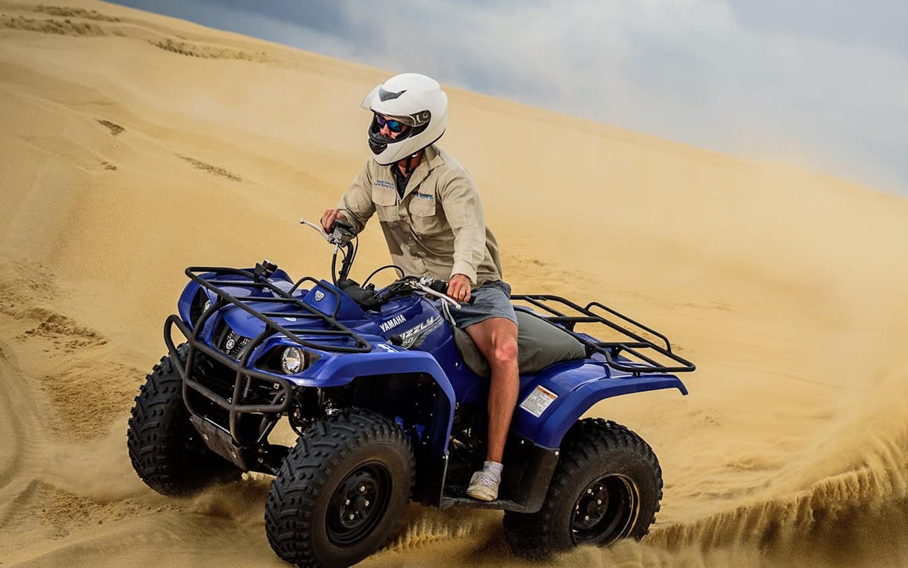 Quad biking on Stockton Sand Dunes during a safari tour.