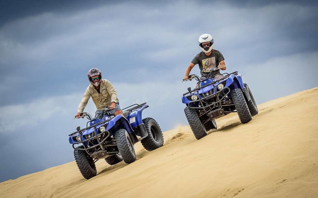 Quad biking on Stockton Sand Dunes during a safari tour.