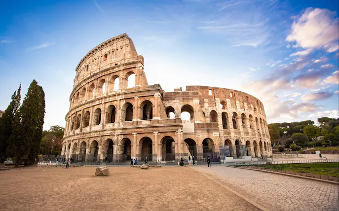Colosseum in Rome with tourists exploring the ancient amphitheater.