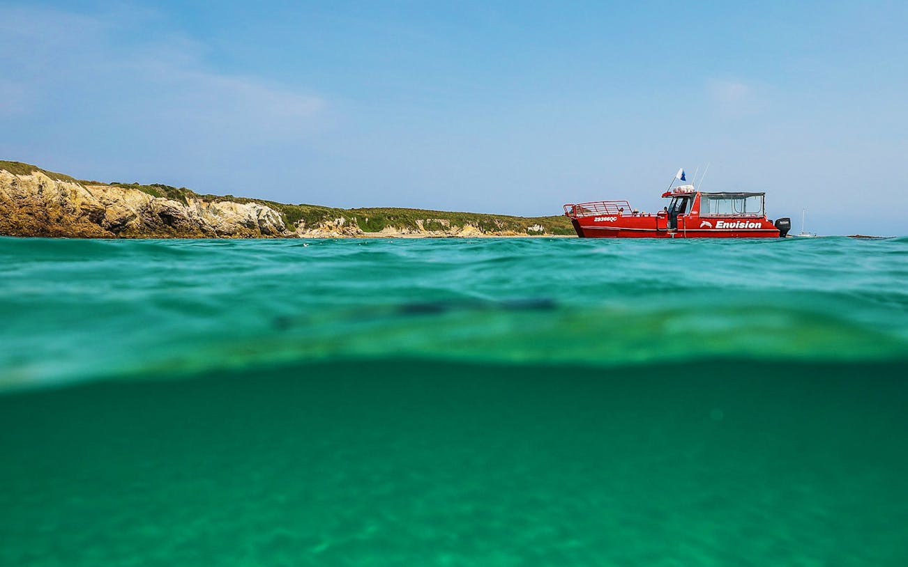 Red boat near Broughton Island with clear turquoise water.