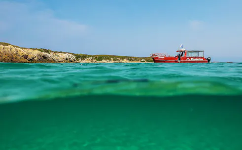 Red boat near Broughton Island with clear turquoise water.