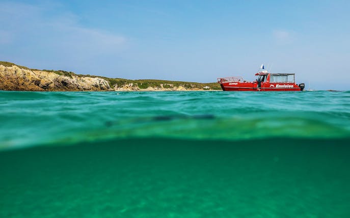 Red boat near Broughton Island with clear turquoise water.