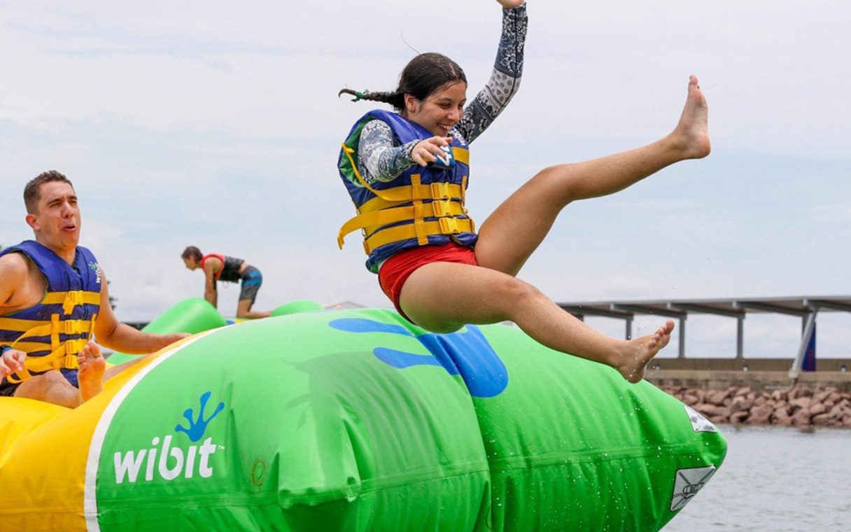 Person jumping on inflatable at Darwin Waterfront Recreation Lagoon Aqua Park.