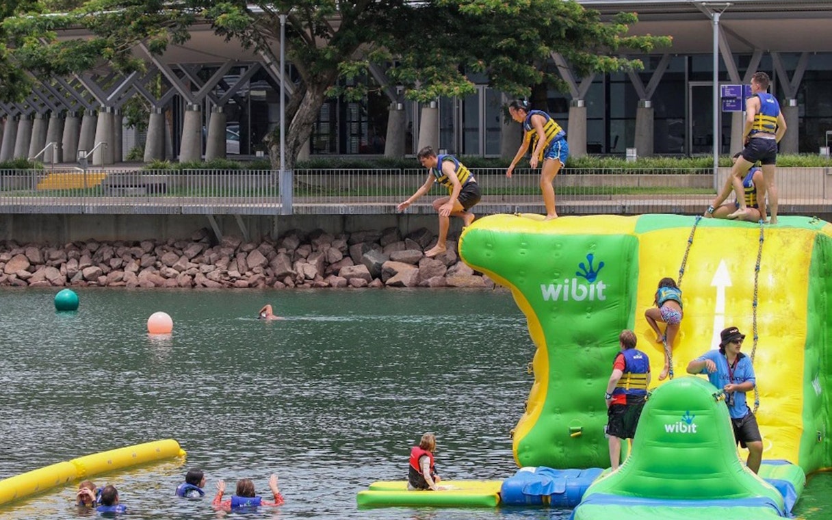Visitors enjoying inflatable aqua park at Darwin Waterfront Recreation Lagoon.