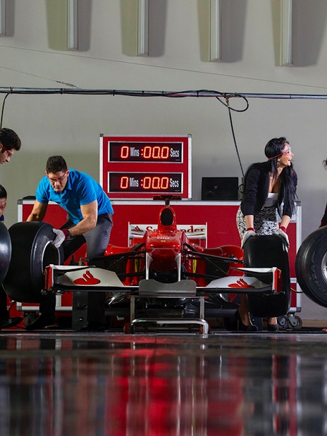 People participating in a pit stop activity at Ferrari World Abu Dhabi.