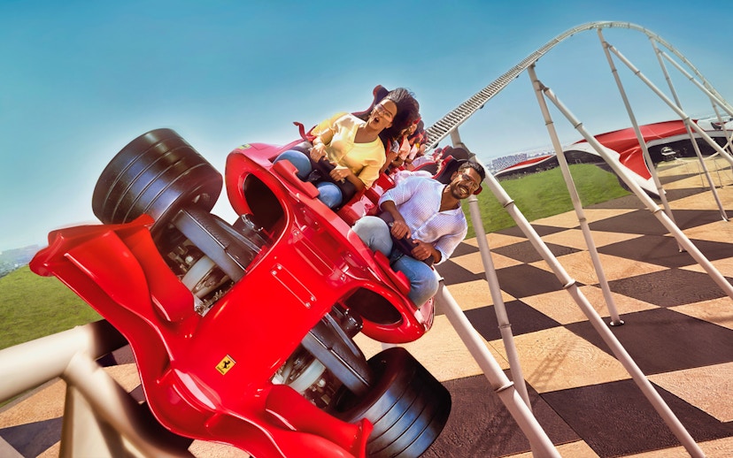 Roller coaster at Ferrari World Abu Dhabi with excited riders.