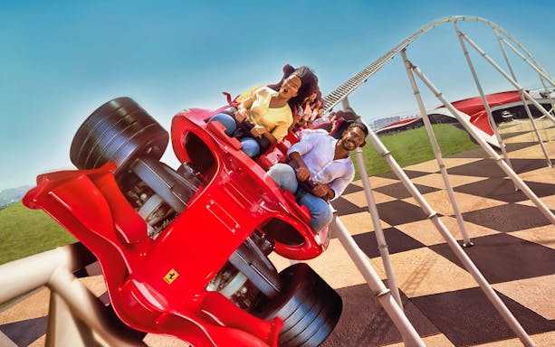Roller coaster at Ferrari World Abu Dhabi with excited riders.