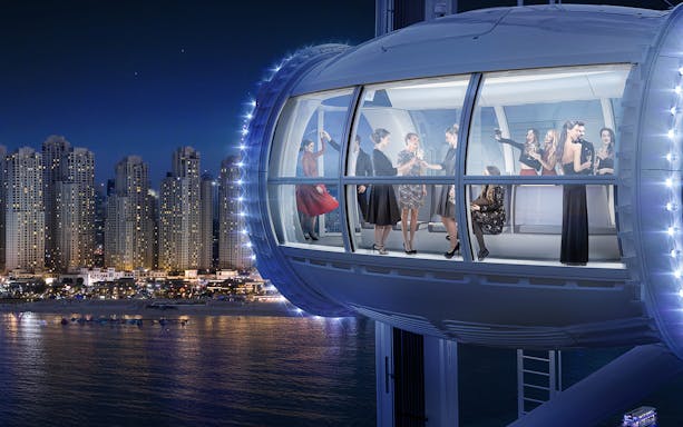 Guests enjoying a night view from Ain Dubai Lounge Plus capsule.