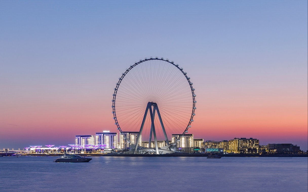 Ain Dubai observation wheel at sunset with city skyline in the background.