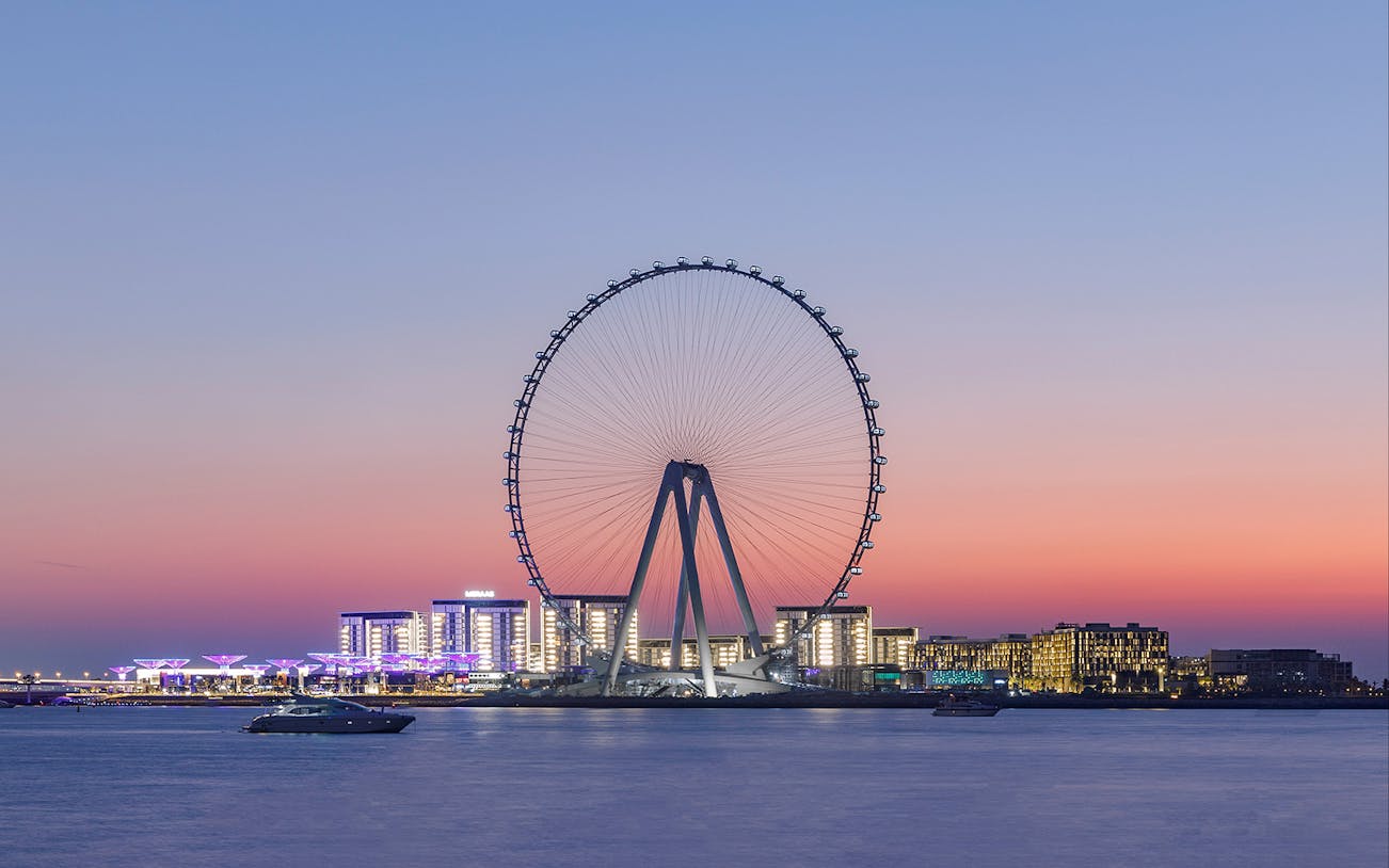 Ain Dubai observation wheel at sunset with city skyline in the background.