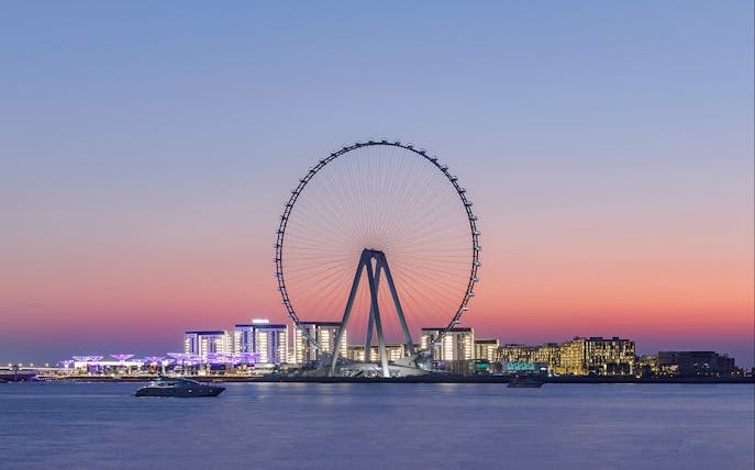 Ain Dubai observation wheel at sunset with city skyline in the background.