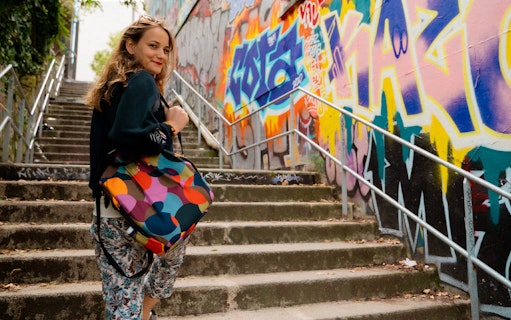 Woman exploring colorful graffiti on Belleville street art tour.