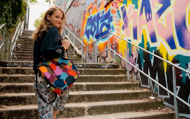 Woman exploring colorful graffiti on Belleville street art tour.