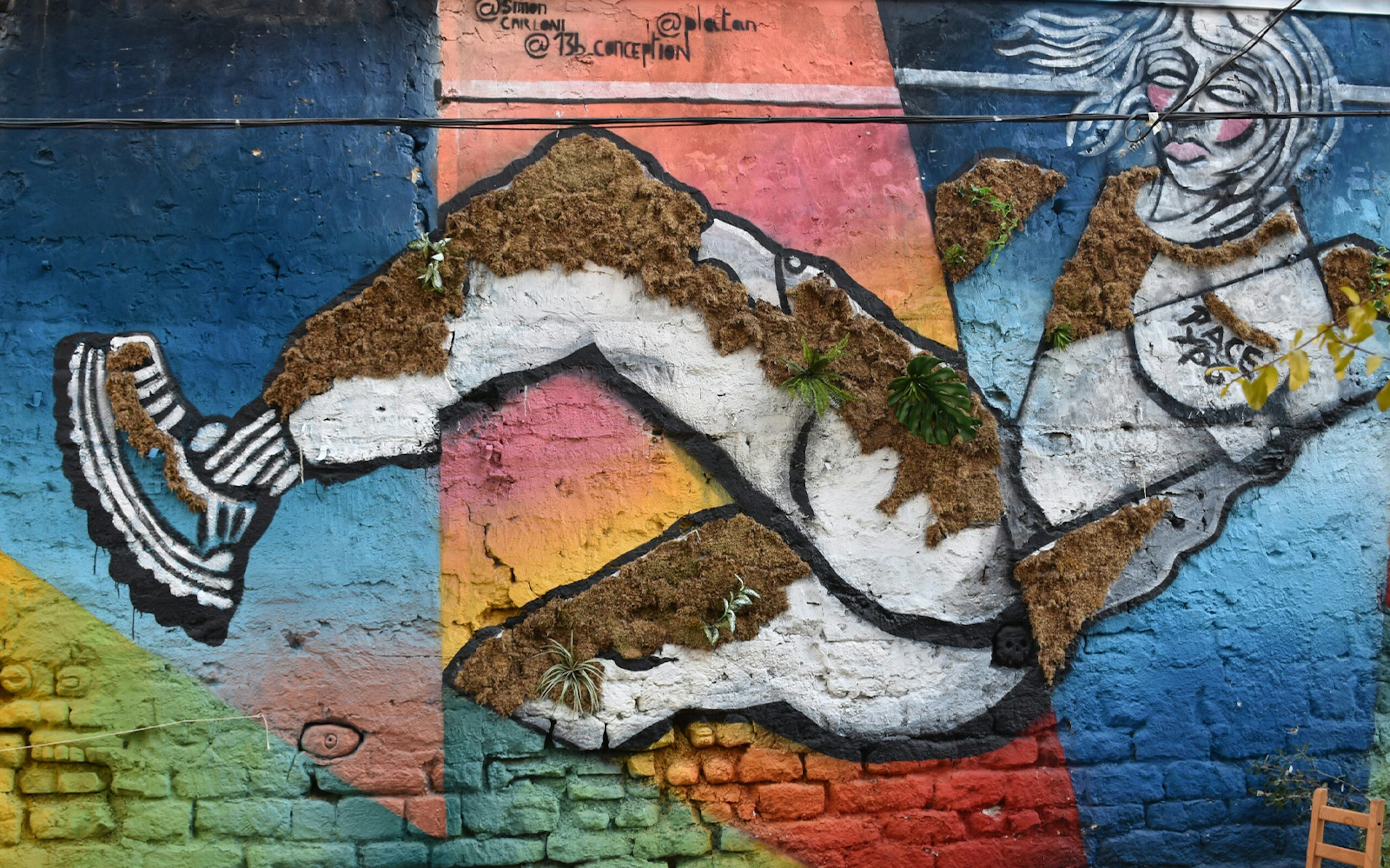 Street art mural featuring a dynamic figure with colorful geometric background.