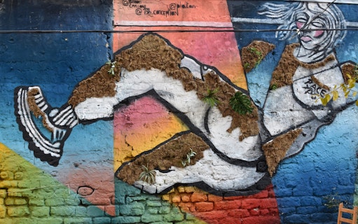 Street art mural in Belleville featuring a dynamic figure with colorful geometric background.