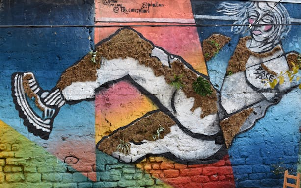 Street art mural in Belleville featuring a dynamic figure with colorful geometric background.