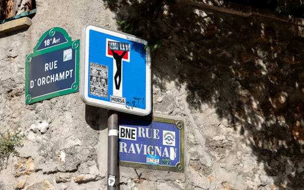 Street signs with artistic graffiti in Montmartre, Paris.