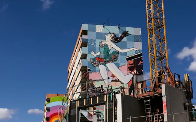 Building with large mural of a dancing figure on the Murals XXL Street Art Tour.