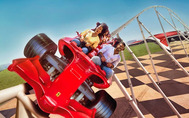 Roller coaster at Ferrari World Abu Dhabi with excited riders.