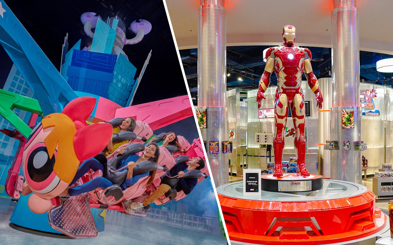 Iron Man statue at IMG Worlds of Adventure, Dubai, with visitors exploring the theme park.