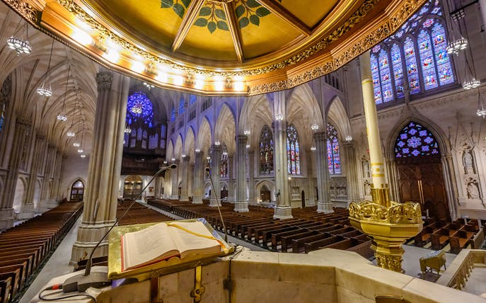 St. Patrick's Cathedral interior with view from pulpit, showcasing stained glass windows and vaulted ceilings.